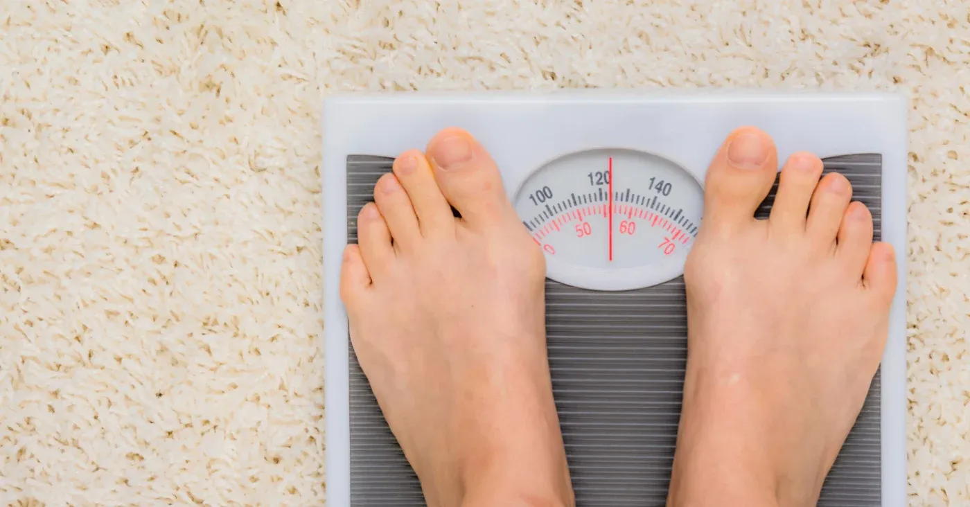 two feet standing on bathroom scale